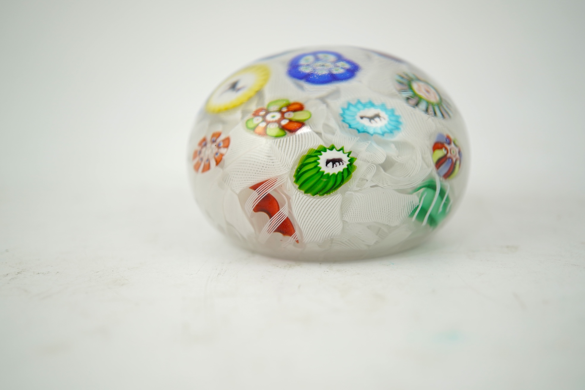 A Baccarat silhouette cane upset muslin ground paperweight, one cane dated 1848